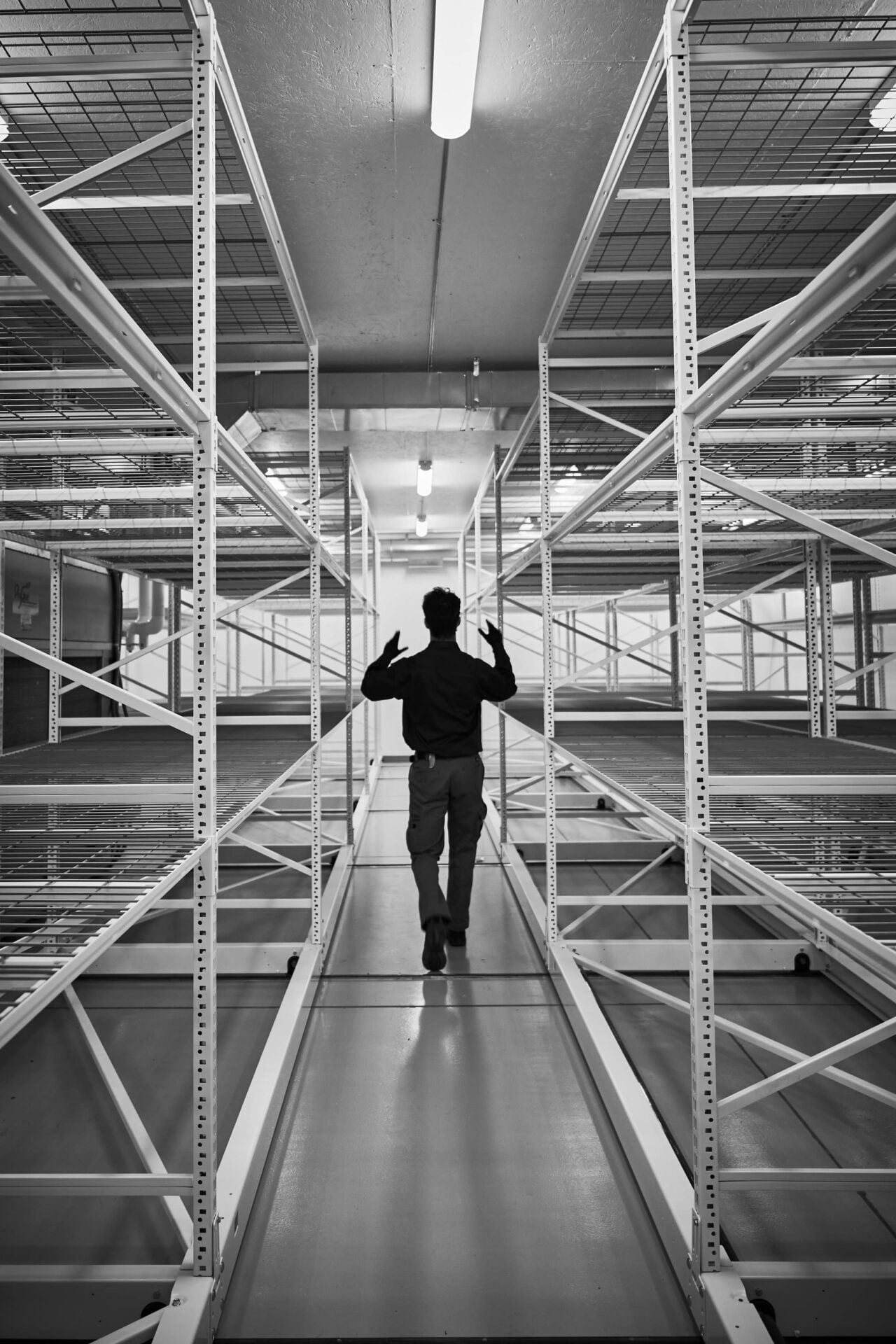 a guy passing empty industrial shelves